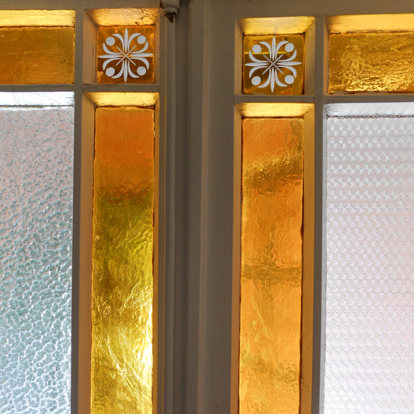 Detailaufname einer Türverglasung mit unterschiedlich gestalteten Glasflächen.